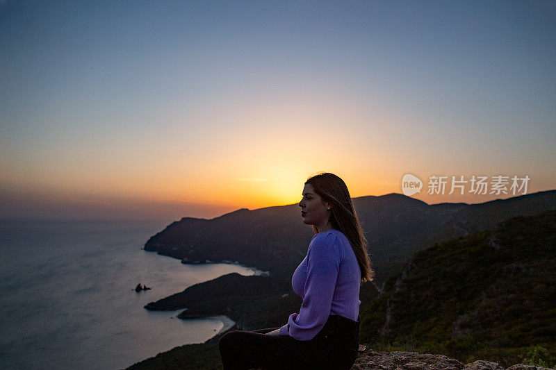 一位女士在Portinho da欣赏日落Arrábida